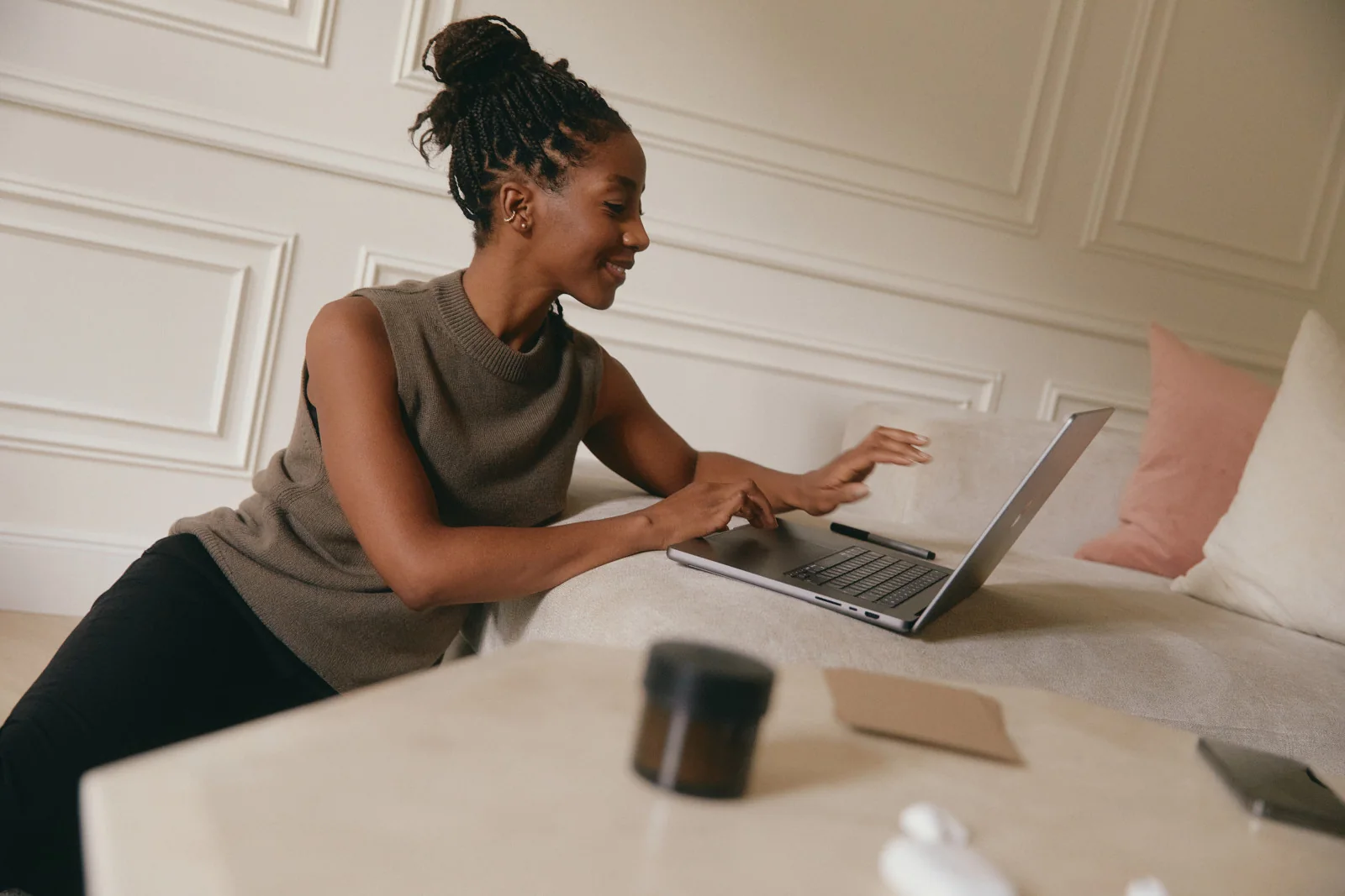 A person working with a laptop, notebook and cup