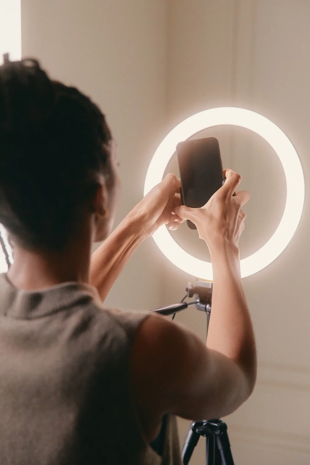 Hands holding a phone near a circular light